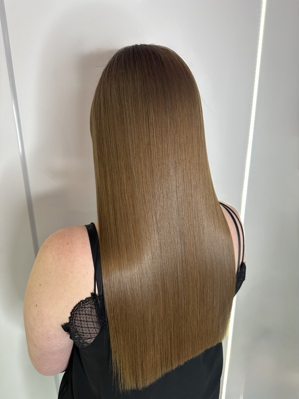 Résultat lisse et miroir sur cheveux châtain clair.